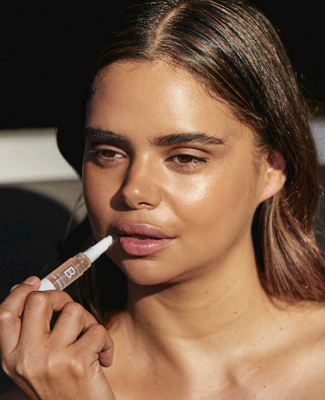 girl putting lip serum on her lips