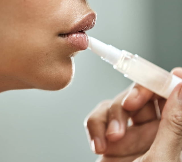 woman putting lip serum