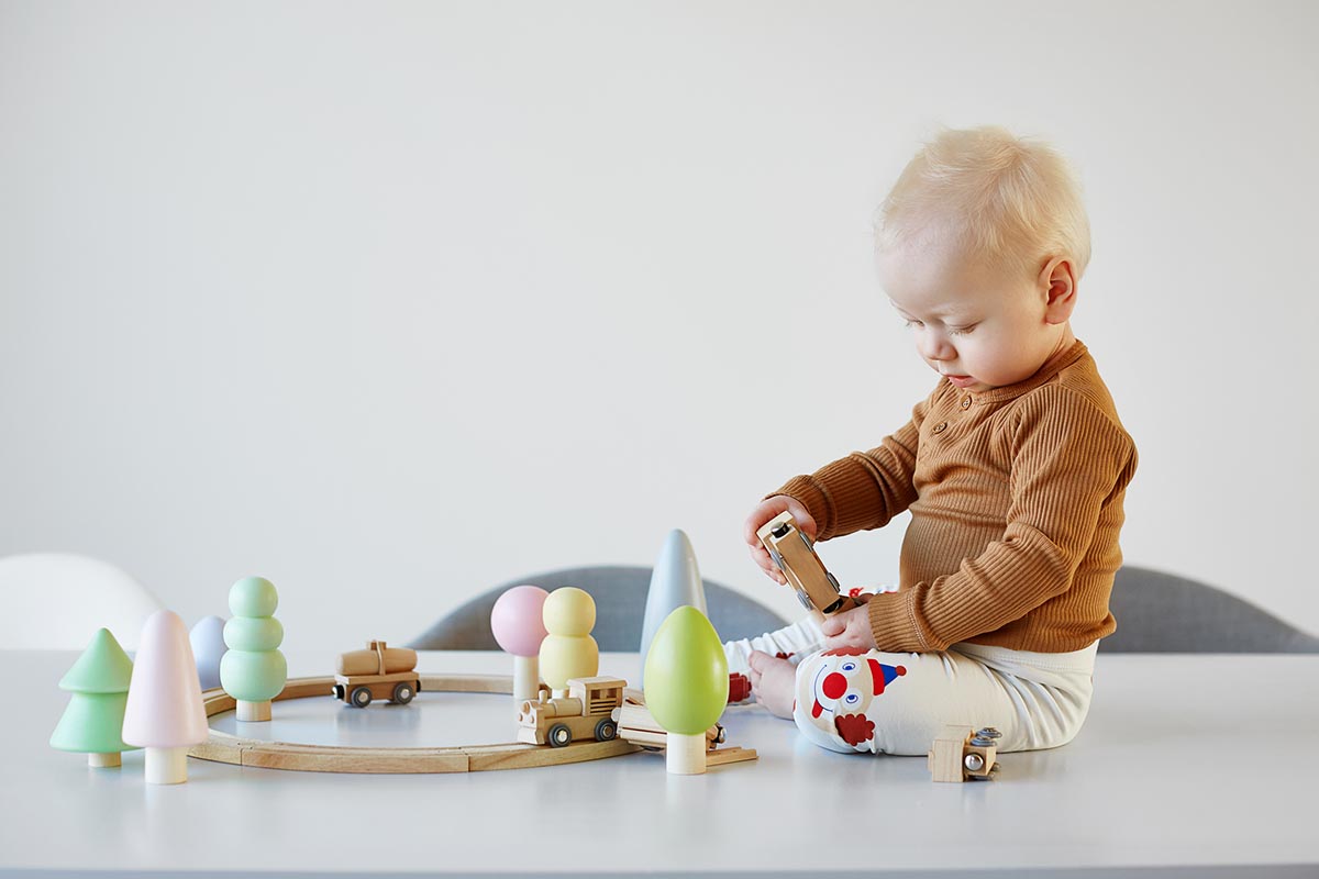 A child plays with a wooden train.
