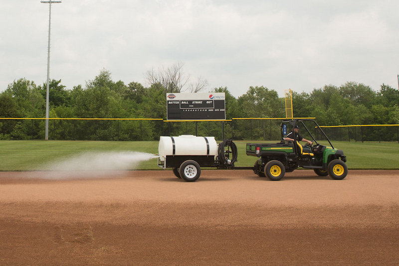 Man watering the ground with water trailer