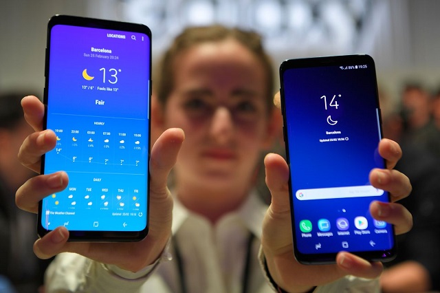 woman holding two samsung refurbished phones