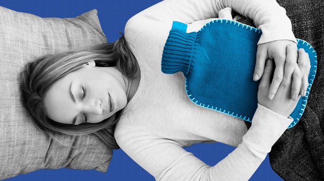 woman lying and holding hot water bottle