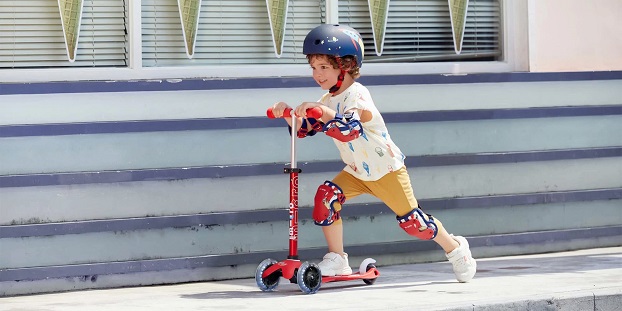 kid driving scooter and looking happy