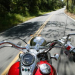 Cruiser motorcycle on a open road from rider point of view.