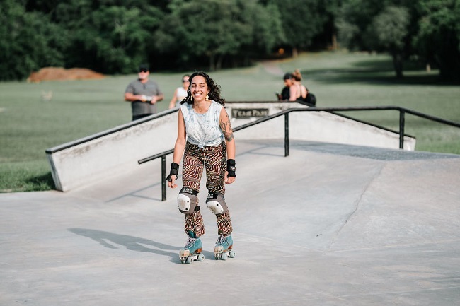 picture of a woman driving roller sates in park wearing protective gear 