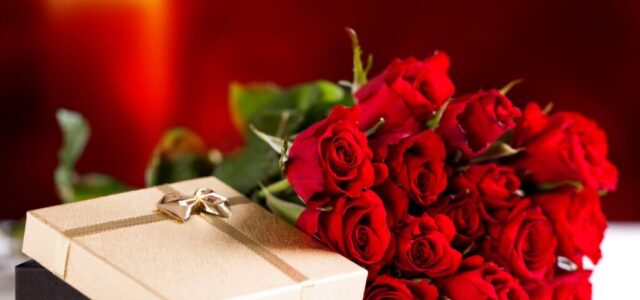 Bouquet of roses and unpacked present for Valentine's day