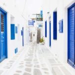 Greek Street in Mykonos with blue doors and white floor and walls