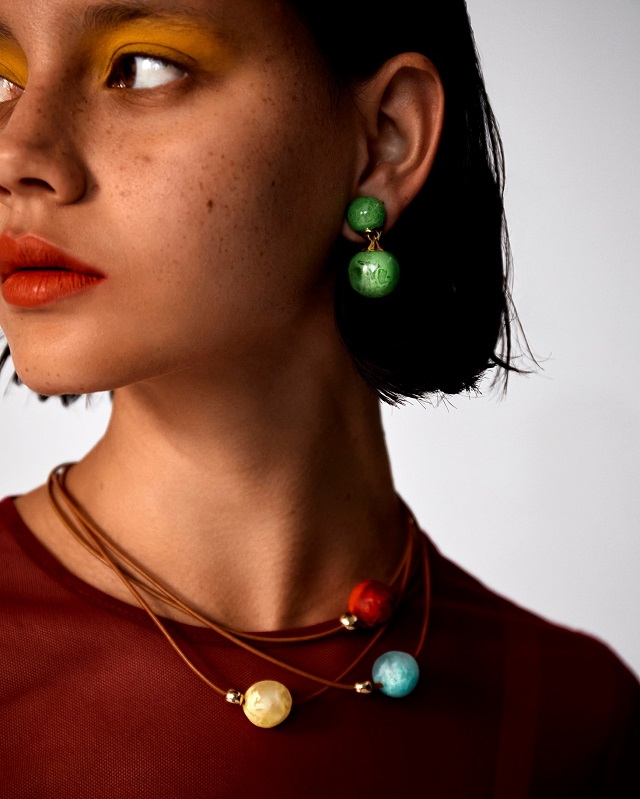 woman wearing resin jewelry, necklaces, and earrings
