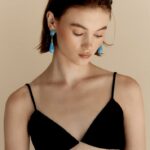 woman wearing blue resin earrings