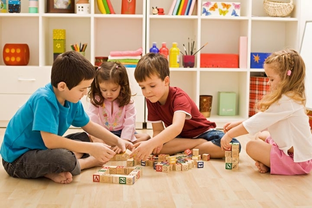 four little kids playing spelling games