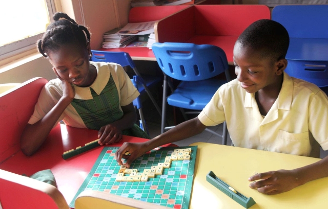 two kids playing spelling game - scrabble