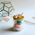 Delicate French macarons in pastel colors presented in a small glass jar with a gold lid and decorative ribbon.