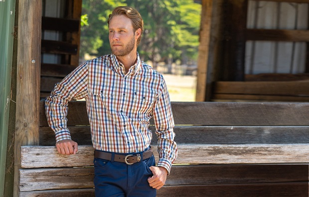 a man dressed in cowboy style with a shirt, jeans, and a belt