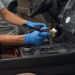 Automotive industry worker carefully detailing car interior