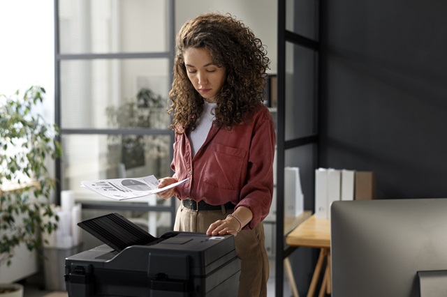 a woman using a printer in a modern office