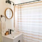 bathroom with mirror, vanity, and shower