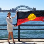 woman holding aboriginal flag