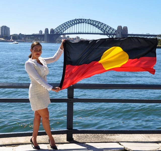 woman holding aboriginal flag